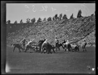 USC Trojan football player carries a ball through Oregon State's defense, Los Angeles, circa 1928-1929