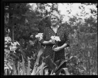 Agnes B. Fredericks holding a rare crinum lily in her garden, Los Angeles, 1930s