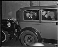 Clarence M. Fuller and Raymond W. McKee sit in the back of a prisoner transport vehicle, Los Angeles, between 1931-1934