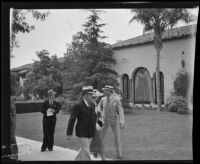 Ingle Barr, Delpha Barr and George Millovich walk down the sidewalk in front of the Gettle residence, Beverly Hills, 1934
