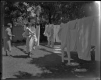 Two unidentified women hanging laundry on a clothesline at the Gettle house in Beverly Hills, 1935