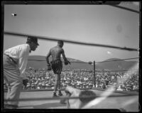 Boxers Tiger Flower, walking, and Eddie Huffman and a referee at Ascot Park, Gardena, 1926