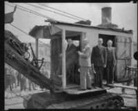 Mayor Frank L. Shaw at the helm of a steam shovel with 3 other men at Fort Moore Hill, Los Angeles, 1934
