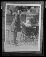 Chinese woman pushing a baby buggy with a baby in Chinatown, 1920-1935