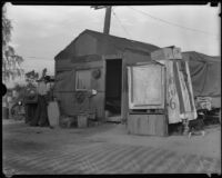 Resident of Hooverville stands in front of his home, Los Angeles, 1930s