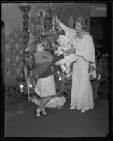 Aimee Semple McPherson gives a doll to a little girl for Christmas present, Los Angeles,