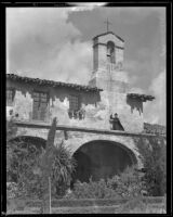 Priest holds a rope for a bell at Mission San Juan Capistrano, 1920/1939
