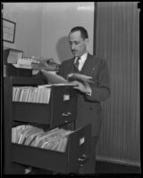 Volney P. Mooney Jr. searches through a filing cabinet, Washington D.C., 1935