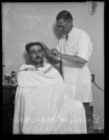 A barber named Parkers gives Loren W. Mendell a haircut, Los Angeles, 1929