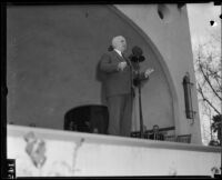 Governor Frank Merriam speaking on a stage, California, 1934-1939