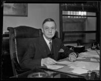 Frank Nance, coroner, seated at his desk, Los Angeles, 1935