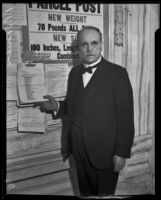 Postmaster P. P. O'Brien standing beside a post office bulletin board, Los Angeles, 1933