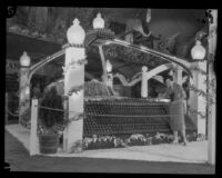 Woman stands next to the Cucamonga and Alta Loma display at the National Orange Show, San Bernardino, 1926