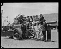 Women seated on a canon at the Pacific Southwest Exposition, Long Beach, 1928