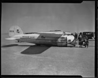 Wiley Post's airplane, Winnie Mae, sits on the desert floor after a failed transcontinental flight, Muroc Dry Lake, circa 1935