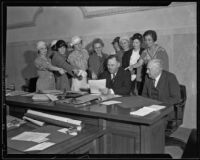 John R. Quinn and a group of women look at a document in his office, Los Angeles, 1930-1936