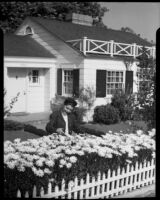 Eleanor Handy with daisies in garden, [1940s?]