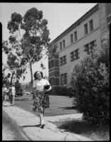 Mrs. Joe Raymond walking with books near Franz Hall, University of California, Los Angeles, 1946