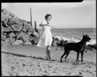 Ruth Bertrand on beach with dog, Long Beach, 1940