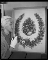 Dane Gorrell with 1888 horseshoe-shaped shell art wreath made by poet Ina Donna Coolbrith, Santa Monica, 1953