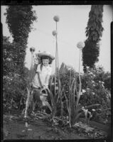 Helena Burnett watering flowers in a garden, 1947-1950