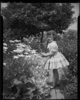 Helena Burnett in a garden with daisies, 1947-1950
