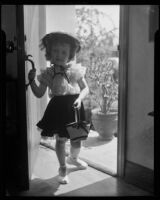 Helena Burnett in blouse, skirt and hat holding a basket, Santa Monica, 1947-1950