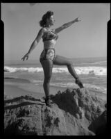Leonora Preston posing en ecarte in pointe shoes at the beach, Santa Monica, 1951