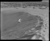 Mona Ohrtland (possibly) walking on a sand dune in the desert, circa 1940-1945