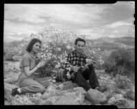 Paul P. Wilhelm and Marcella seated in front of a bank of wild flowers at 1000 Palms Ranch, Thousand palms vicinity, 1939