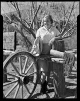 Dorie Doney next to a wagon wheel at 1000 Palms Ranch, Thousand Palms vicinity, 1941