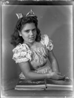 Barbara Lee Tramutto at a table in front of an open book, circa 1947