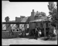 Group of people in front of Pueblo Revival style building, Palm Springs, 1936