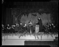 Natalie Garrotto with orchestra on stage perhaps for a United Nations event, circa 1950