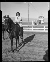 Female equestrian in the saddle at a horse show at the Palm Springs Field Club, Palm Springs, 1937