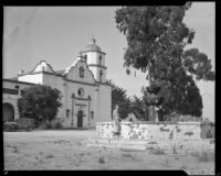 Carolyn Bartlett standing in front of the church at Mission San Luis Rey de Francia, Oceanside, 1936