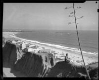 Woman seated on the cliff edge of the Idaho path with the beach beyond, Santa Monica, 1938