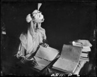 Eugene d'Orange seated at desk with notebooks, Santa Monica, 1931