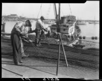 Men stringing nets on the dock at Long Beach Harbor, Long Beach, 1930