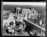 Vacationers on a sunny terrace overlooking the coast of Southern California and a fleet of ships, Long Beach, 1933