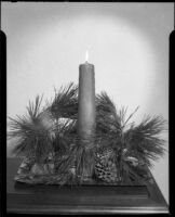 Decorative arrangement with candle, pine tree cuttings and pine cone, Santa Monica, 1940-1945