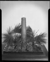 Decorative arrangement with candle, pine tree cuttings and pine cone, Santa Monica, 1940-1945