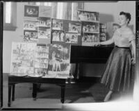 June Moss standing next to layouts of photographs showing her performing in operas, Santa Monica, 1955