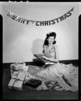 Lucille Maser seated on the floor with Christmas presents, Santa Monica, circa 1941