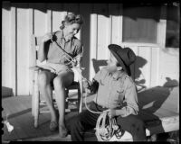 Mona Ohrtland seated on a front porch with cowboy Johnny Boyle, 1940