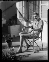 Mona Ohrtland seated in a patio, Palm Springs, 1940