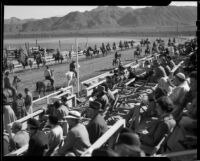 Spectators in the stands watch equestrians on the track at  the Palm Springs Field Club, 1937