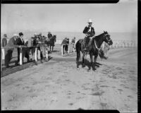 Cowboy on a horse on the track of the Palm Springs Field Club during a rodeo event, circa 1941