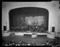 Conductor and orchestra onstage, perhaps for a United Nations event, circa 1950