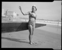Evelyn Most on the beach with longboard, Santa Monica, 1944